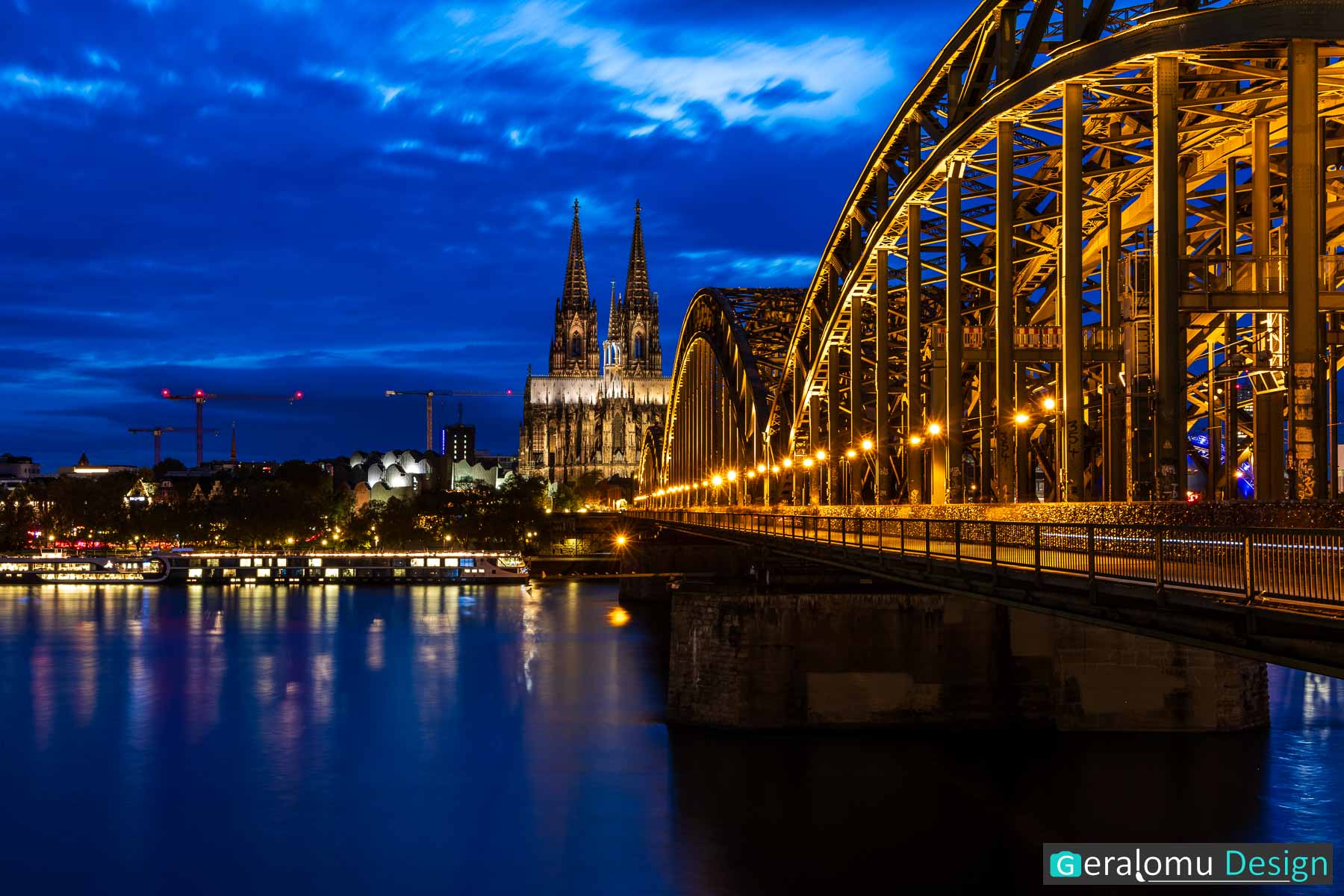 Diese Langzeitfotografie zeigt den Kölner Dom mit der Hohenzollernbrücke zur blauen Stunde.